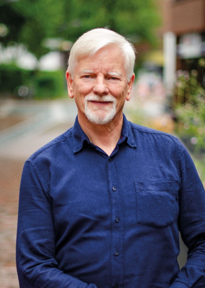 Portrait von Manfred Zilske vor einer stilisierten grünen Sonnenblume