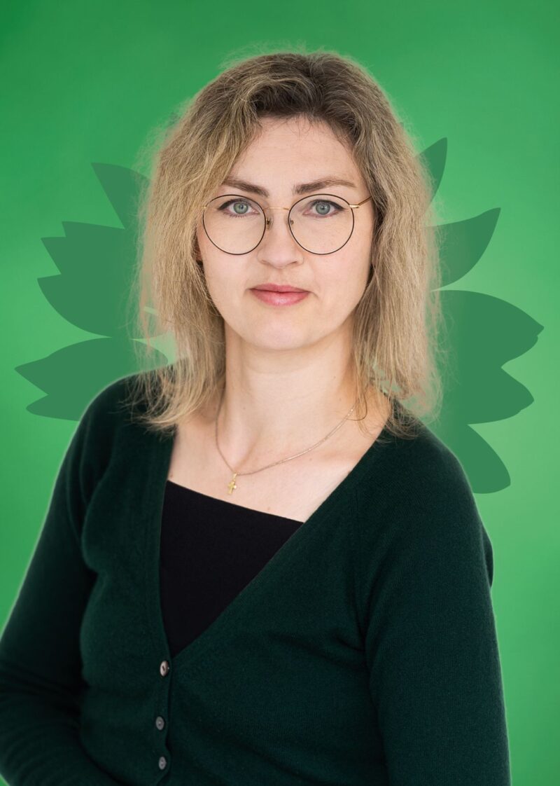 Portrait von Rita Zimmermann vor einer stilisierten grünen Sonnenblume